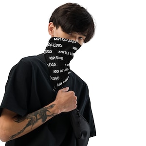 May include: Black neck gaiter with the text "ANY DJ LOGO" in white. The neck gaiter is worn by a person wearing a black t-shirt and holding a black bag. The person has a tattoo on their arm.