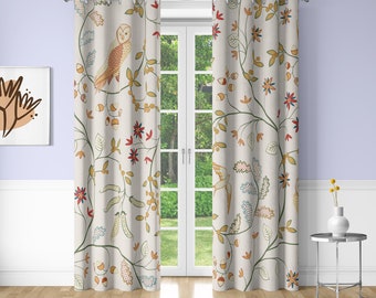 Peut inclure: Une paire de rideaux blancs avec un motif floral représentant des oiseaux, des feuilles et des fleurs dans des tons de rouge, jaune, vert et bleu. Les rideaux ont des œillets en haut et sont accrochés à un cadre de fenêtre blanc.