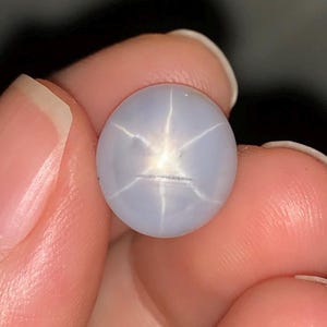 May include: A light blue star sapphire gemstone with a six-pointed star.
