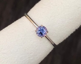 Puede incluir: Un anillo de plata con una piedra preciosa redonda de color púrpura engastada en garras.