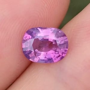 以下が含まれることがあります： ファセットカットされた、鮮やかなパープルのオーバル型の宝石です。