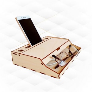 May include: A wooden organizer with a slot for a phone, a compartment for glasses, and a small drawer. The organizer is made of light wood and has a natural finish.