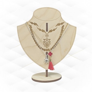 May include: A wooden necklace display stand with a heart-shaped base and a decorative cutout design. Two necklaces with pendants are displayed on the stand. One necklace has a silver pendant with a star design and the other has a red pendant with a cross design. The necklaces have a gold chain and a silver chain.