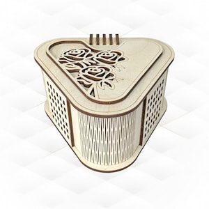 Könnte beinhalten: Eine herzförmige Holzkiste mit einem zarten, ausgeschnittenen Blumendesign auf dem Deckel. Die Kiste hat eine helle Holzoptik und aufwendige Gitterarbeiten an den Seiten.