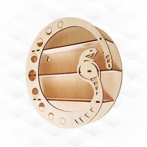 Könnte beinhalten: Ein rundes Wandregal aus Holz mit einem Schlangendesign. Das Regal hat drei Ebenen und ein Mondphasen-Design am Rand.