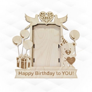 May include: A wooden photo frame with a cutout of a teddy bear holding a heart and balloons. The frame has a banner that reads "Happy Birthday to YOU!" and a cutout of two doves with a heart at the top.