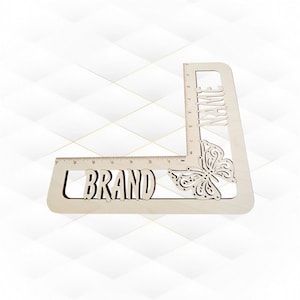 May include: Wooden ruler with a butterfly design and the words "BRAND" and "NAME" engraved on it.