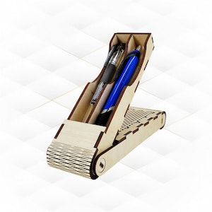 May include: A wooden pen holder with a distinctive design, containing a black pen and a blue pen. The holder is made of light-coloured wood and has a slanted compartment for pens. The base features a decorative pattern.