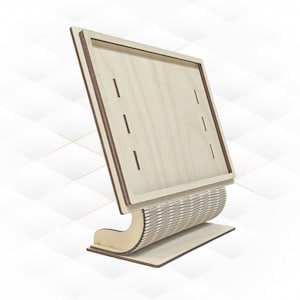 May include: A wooden display stand with a rectangular frame and a curved base. The stand is made of light-colored wood and has a natural finish.
