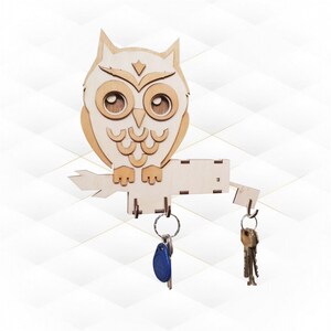 May include: Wooden owl key holder with three key rings. The owl is painted white with brown accents and has large, round eyes. The owl is perched on a branch with a wooden base.