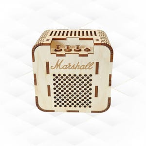 May include: A wooden box resembling a Marshall amplifier. The box is light brown with a series of small holes and vertical lines. The word "Marshall" is engraved on the front. Three knobs are visible on the top.