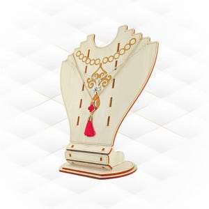 May include: A light-coloured wooden necklace display stand featuring a laser-cut decorative pattern and slots for jewellery. A silver-toned chain necklace with a red clover-shaped pendant and a matching red tassel hangs from the display stand.