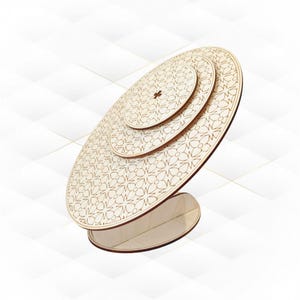 May include: A wooden, tiered display stand with a floral pattern. The stand has three circular platforms of varying sizes, supported by a curved base. The natural wood colour and intricate cut-out design create a decorative and functional piece.