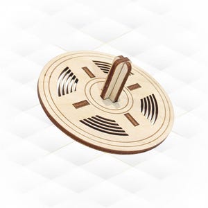 Può includere: Una trottola di legno con una base circolare e un asse centrale. La base presenta un motivo decorativo di cerchi concentrici e linee.