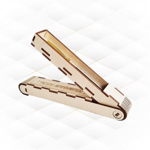 Könnte beinhalten: Eine Holzkiste mit einem Scharnierdeckel, graviert mit den Worten "Happy Anniversary!" Die Kiste ist geöffnet und zeigt einen goldenen Stift im Inneren.
