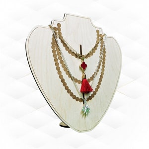 May include: A wooden necklace display stand with three gold and silver necklaces with red tassel pendants.