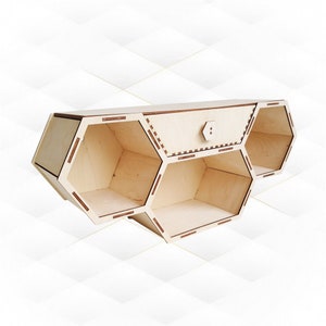 May include: A wooden wall shelf with a honeycomb design. The shelf has three hexagonal compartments and a small drawer in the centre.