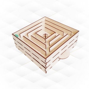 May include: A wooden maze with a small green ball inside. The maze is made of multiple layers of wood and has a complex design.