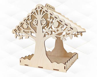 May include: A wooden bird feeder shaped like a tree with a roof. The feeder has a square base and a cutout design of leaves and apples.