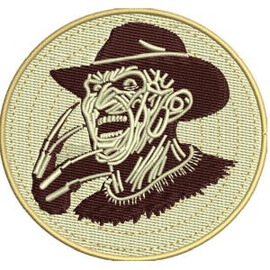 Puede incluir: Parche bordado que representa a un personaje de película de terror con una expresión amenazante. El parche tiene forma circular, con un fondo beige y un borde marrón. El personaje lleva un sombrero marrón.