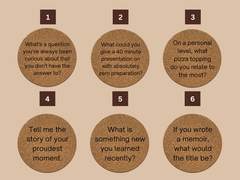 May include: Six brown cork coasters with white text on each. The coasters feature questions to spark conversation. The questions are: "What's a question you've always been curious about that you don't have the answer to?", "What could you give a 40 minute presentation on with absolutely zero preparation?", "On a personal level, what pizza topping do you relate to the most?", "Tell me the story of your proudest moment.", "What is something new you learned recently?", "If you wrote a memoir, what would the title be?"