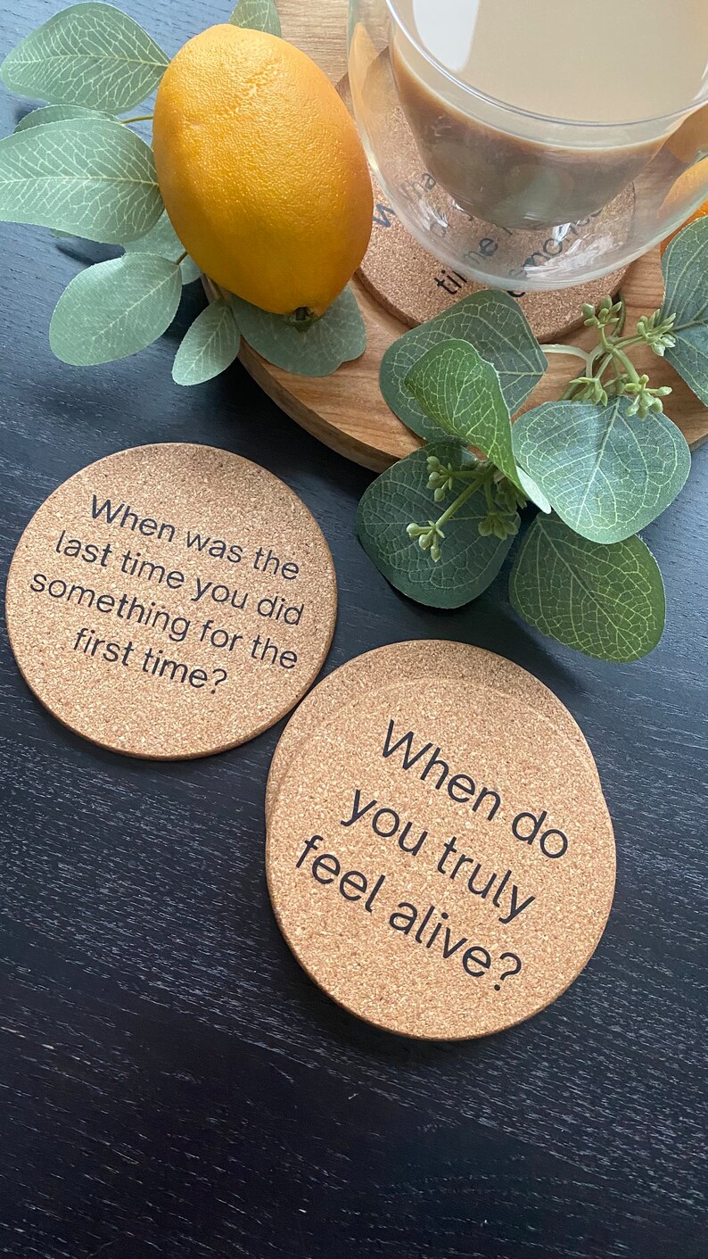 May include: Two cork coasters with black text. The first coaster says "When was the last time you did something for the first time?" The second coaster says "When do you truly feel alive?"