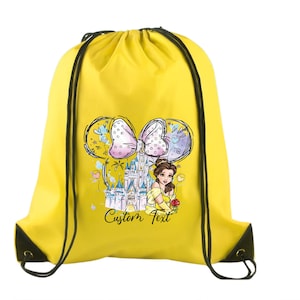 May include: A bright yellow drawstring bag featuring a graphic print of a castle, a character in a yellow dress holding a red rose, and a large polka-dot bow. The design includes the words Custom Text in black script lettering and black cords.