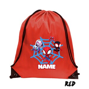 May include: A red drawstring backpack featuring a blue spiderweb design with cartoon Spider-Man characters. The backpack has black drawstrings and the word "NAME" in white block letters. The word "RED" is written in black script at the bottom.