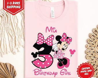 May include: Light pink t-shirt featuring a Minnie Mouse graphic. The design includes the name "Mia", the number "3" with a polka dot bow, and the words "Birthday Girl". The shirt also has a Minnie Mouse illustration and the text "Light Pink".