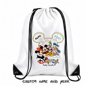 May include: A white drawstring backpack featuring a colorful graphic of Mickey Mouse, Minnie Mouse, Goofy, Donald Duck, Daisy Duck, and Pluto. The design includes a rainbow-outlined Mickey head, fireworks, and the text Disney Family Vacation.