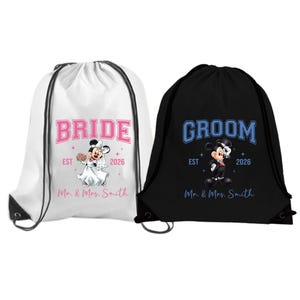 May include: Two drawstring bags, one white and one black, feature wedding-themed designs. The white bag says "BRIDE" in pink, with a Mickey Mouse bride graphic. The black bag says "GROOM" in blue, with a Mickey Mouse groom graphic. Both bags say "EST 2026" and "Mr. & Mrs. Smith."