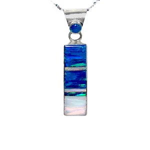 May include: A silver pendant necklace with a blue and white opal stone. The pendant is rectangular in shape and has a small round blue opal stone at the top.