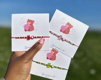 May include: Three friendship bracelets with colorful beads and charms. Each bracelet features a cartoon bear holding a heart and the text "Beaded With Love".