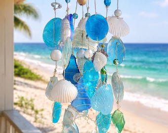 May include: A hanging mobile featuring a central starfish frame with multiple strands of blue and clear glass pieces, white seashells, and small colorful beads suspended by twine. The arrangement creates a layered, cascading display of coastal elements.