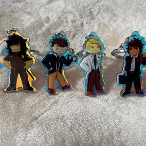 May include: Four iridescent keychains featuring cartoon characters. Each keychain has a different character with a unique design and color scheme. The characters are wearing different outfits, including a suit, a lab coat, and a jacket.