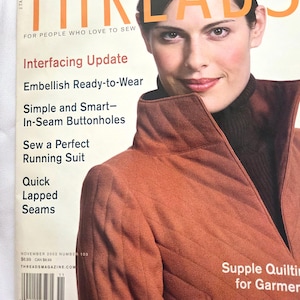 May include: The cover of Threads magazine features a woman wearing a rust-colored quilted jacket. The magazine title is in large orange letters. Text on the cover includes "Interfacing Update" and "Sew a Perfect Running Suit."