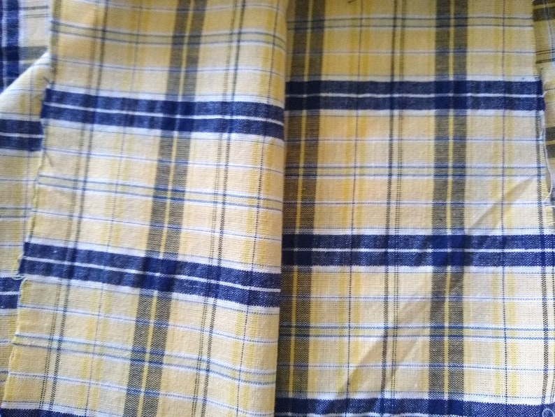 Puede incluir: Tela de cuadros amarillos y azules con textura tejida.