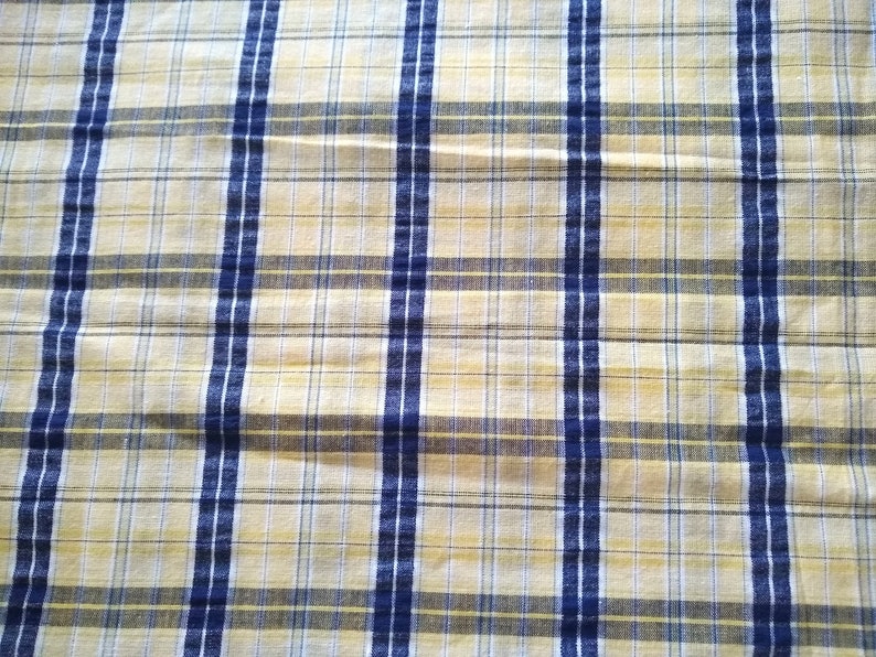 Puede incluir: Una tela de cuadros amarilla y azul con una textura sutil. La tela tiene un patr&oacute;n tejido con finas rayas amarillas y rayas azules m&aacute;s gruesas.
