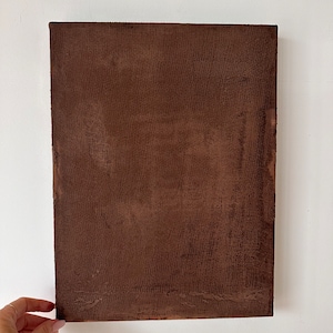 May include: A brown canvas painting with a textured surface.