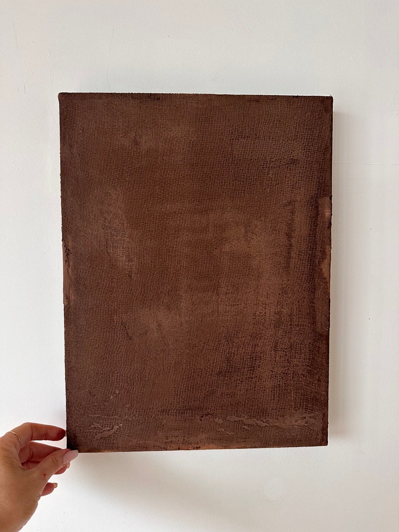May include: A brown canvas painting with a textured surface.