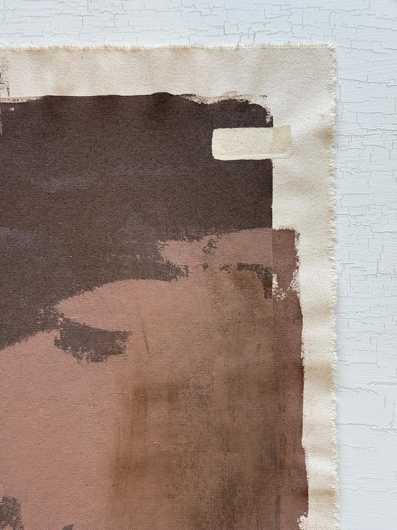 May include: Abstract artwork on canvas featuring a palette of brown, tan, and blush tones. The composition includes broad brushstrokes and a raw canvas edge, creating a textured, artistic aesthetic. The artwork is mounted on a white surface.