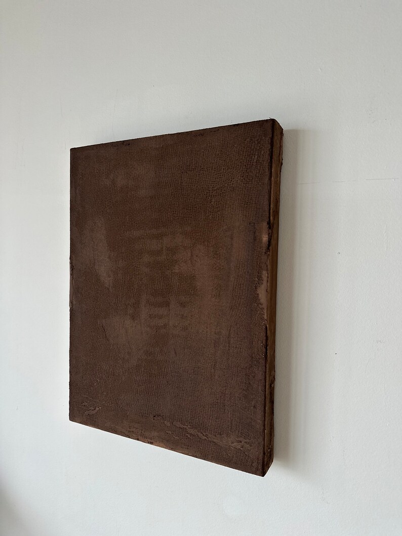 May include: A brown square canvas painting with a textured surface.