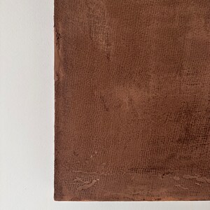 May include: A close-up of a brown textured surface with a fine, woven pattern. The surface is smooth and appears to be made of a durable material.