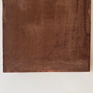 May include: A close-up of a brown textured surface with a fine woven pattern. The surface is slightly rough and has a subtle sheen.