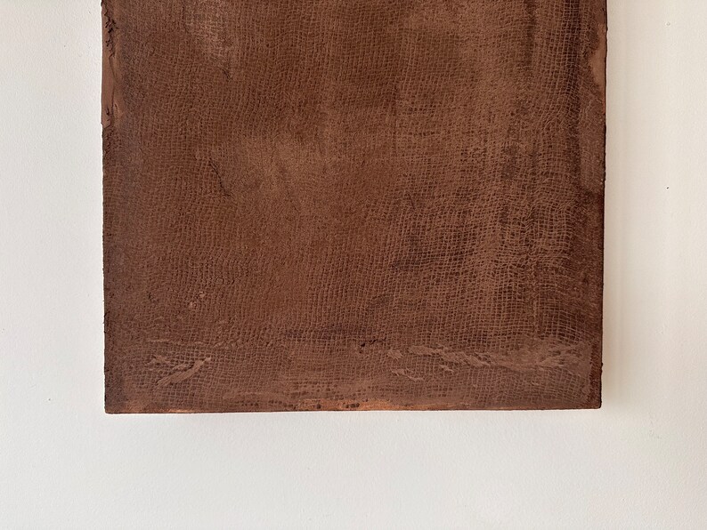 May include: A close-up of a brown textured surface with a fine woven pattern. The surface is slightly rough and has a subtle sheen.