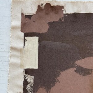 May include: Abstract art canvas with a raw edge. The artwork features a palette of brown, beige, and off-white brushstrokes. The composition includes rectangular and irregular shapes, creating a modern and textured aesthetic.