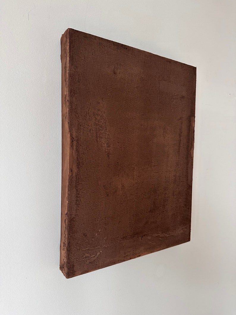 May include: A square brown canvas painting with a textured surface.