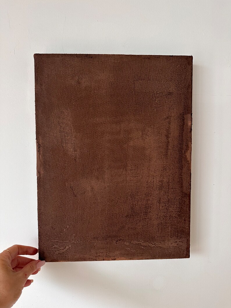 May include: A brown canvas painting with a textured surface.