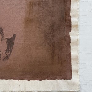 May include: Abstract artwork on canvas featuring shades of brown and tan. The painting has a raw, unfinished edge with visible canvas texture. The color palette is earthy and muted, creating a minimalist aesthetic.
