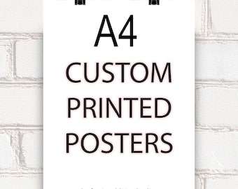 Op de afbeelding: Een wit A4-poster met de tekst "A4 CUSTOM PRINTED POSTERS" in het zwart. De poster wordt vastgehouden door twee zwarte bindclips tegen een witte bakstenen muur. De tekst "Professional Print Quality" staat onderaan.